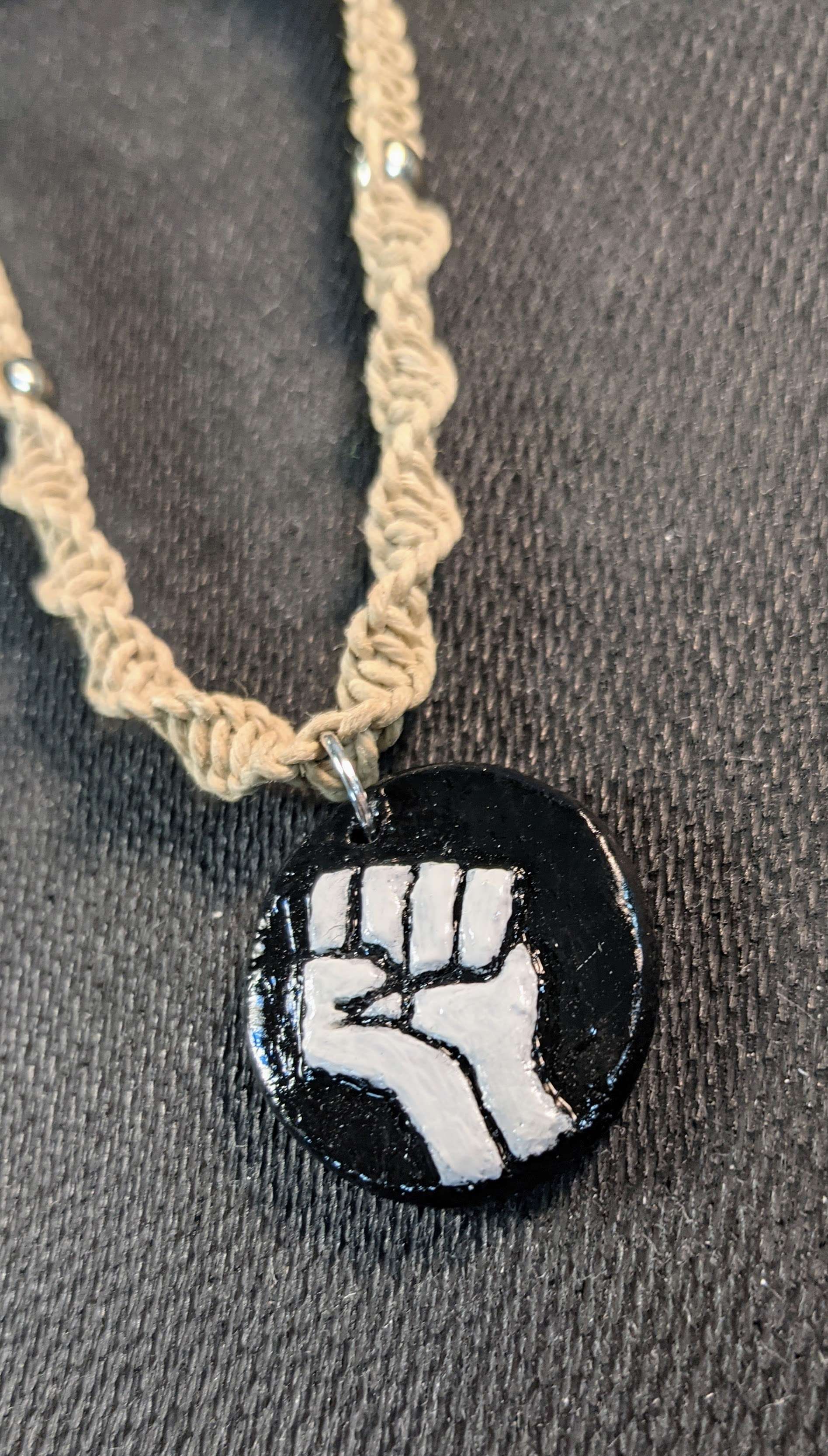 Raised fist pendant on a chain