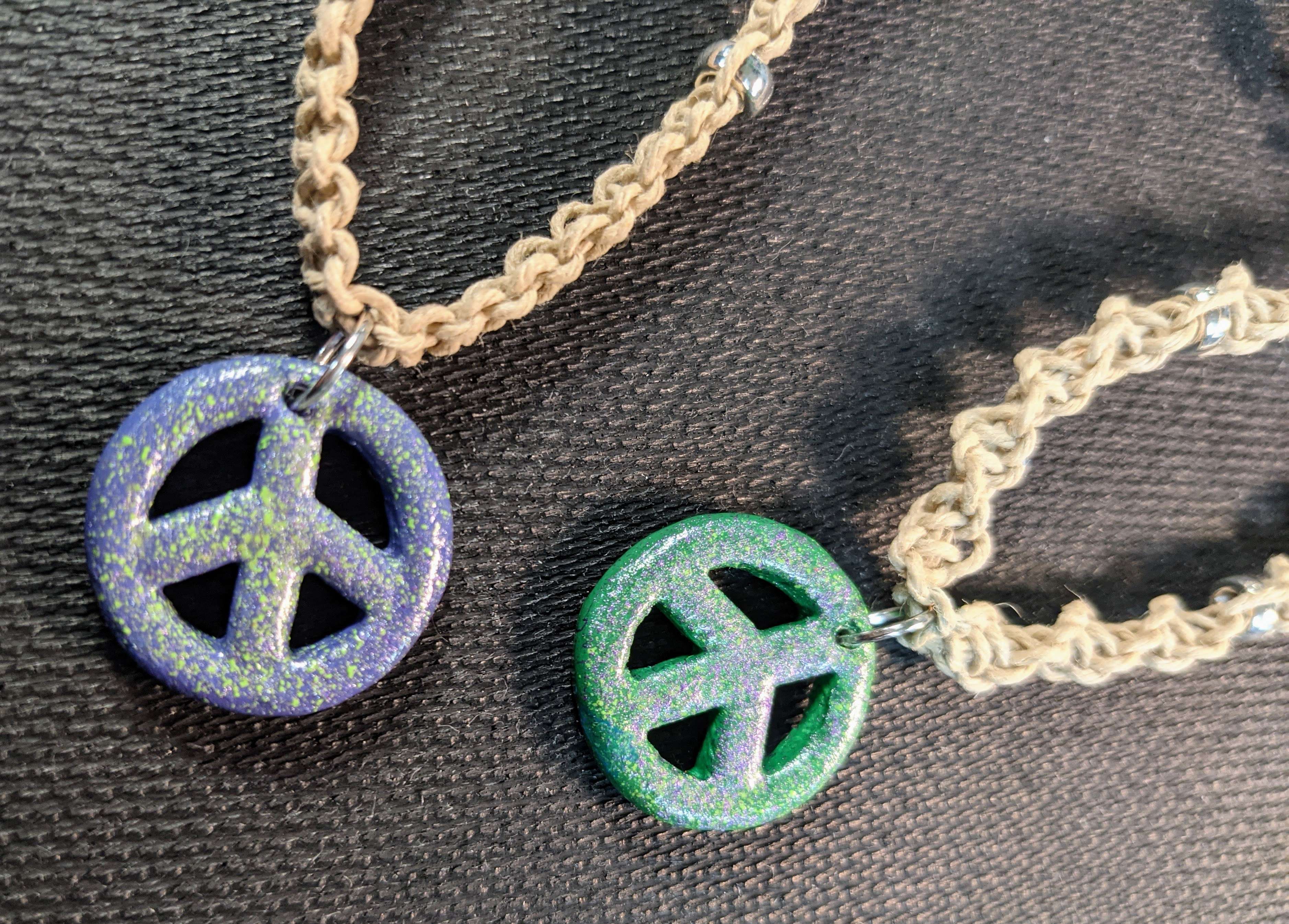 Purple and green peace sign pendants