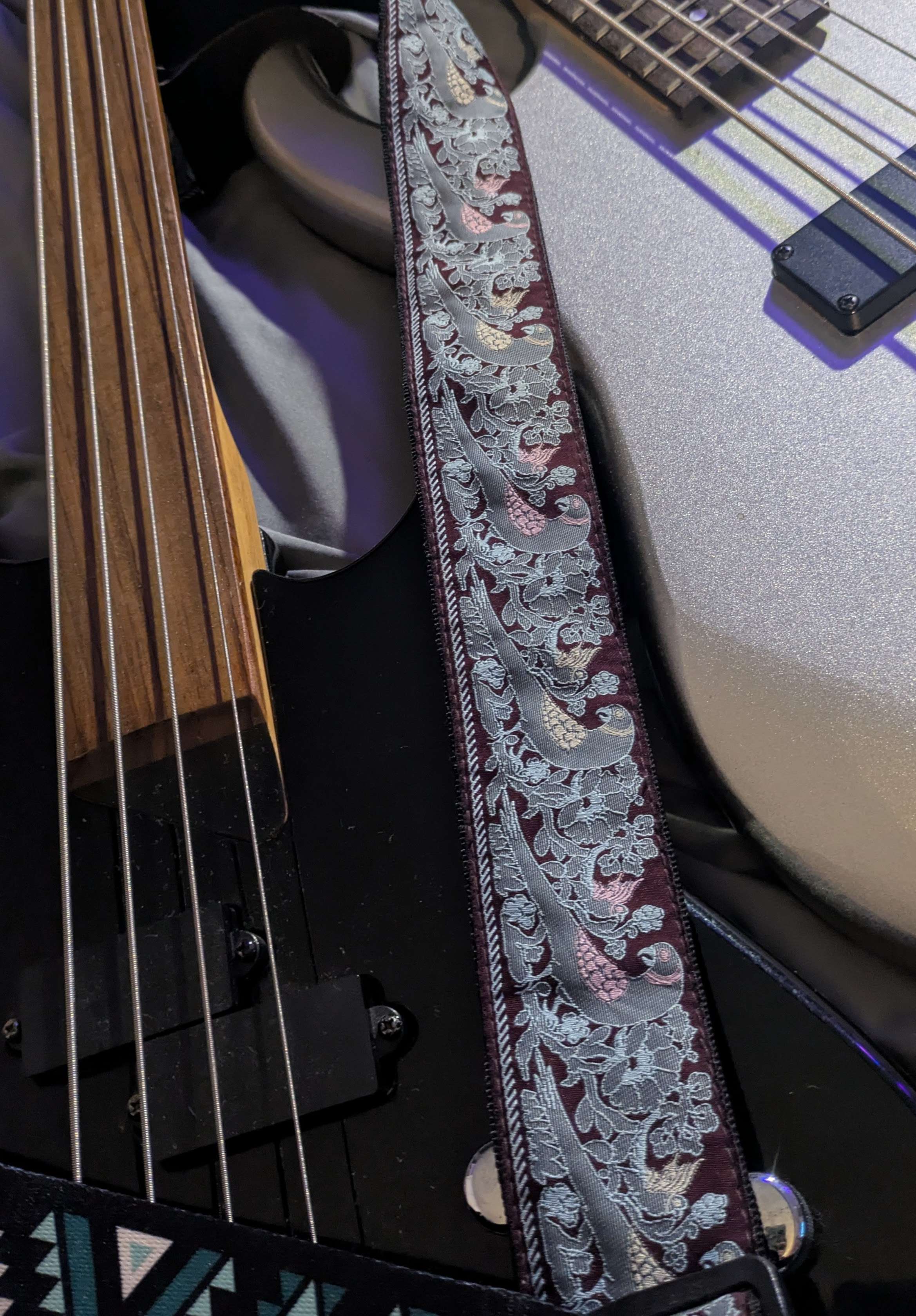 Close view of instruments and a woven guitar strap in Casey Marie Roy’s studio