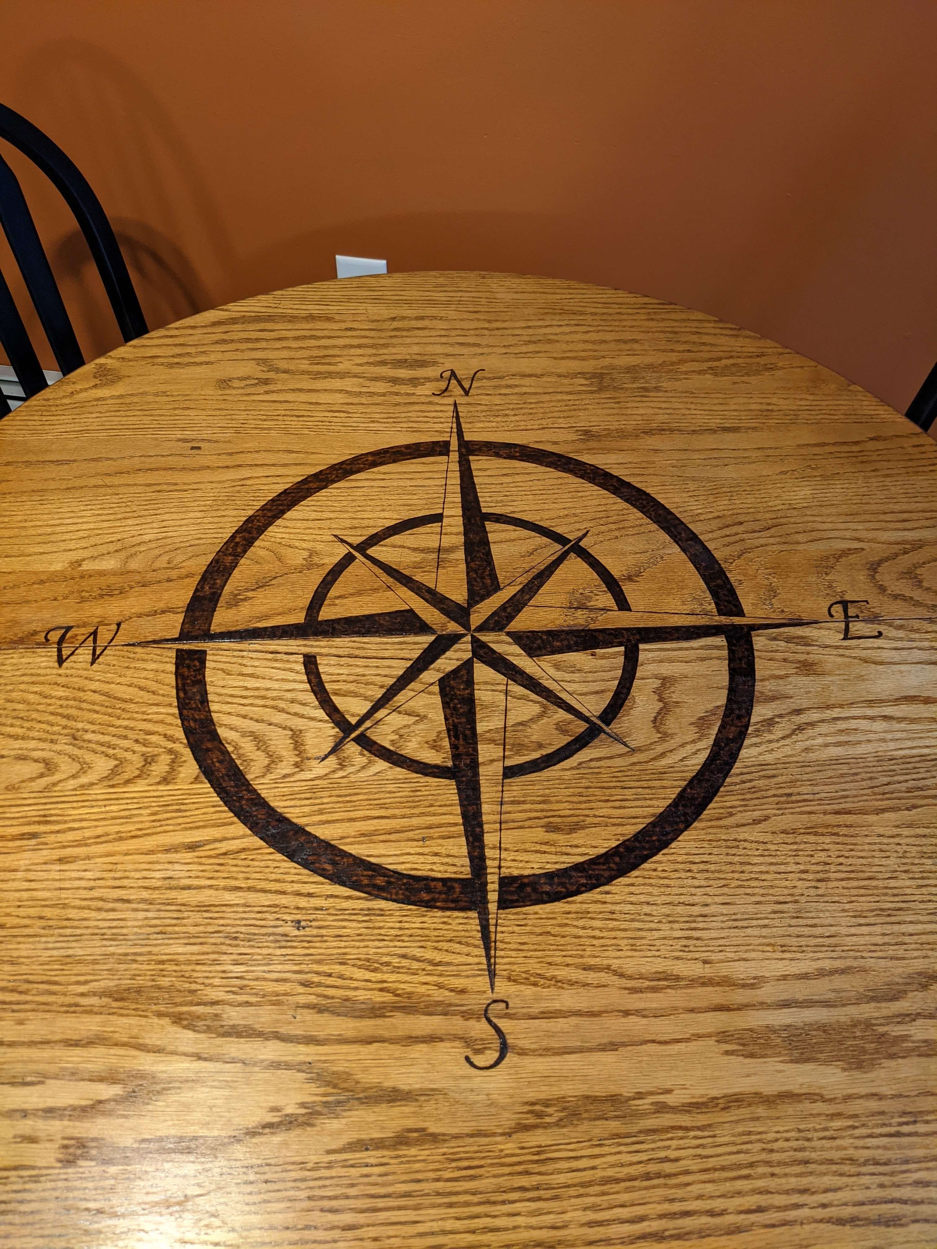 Compass rose burned into a round wood table