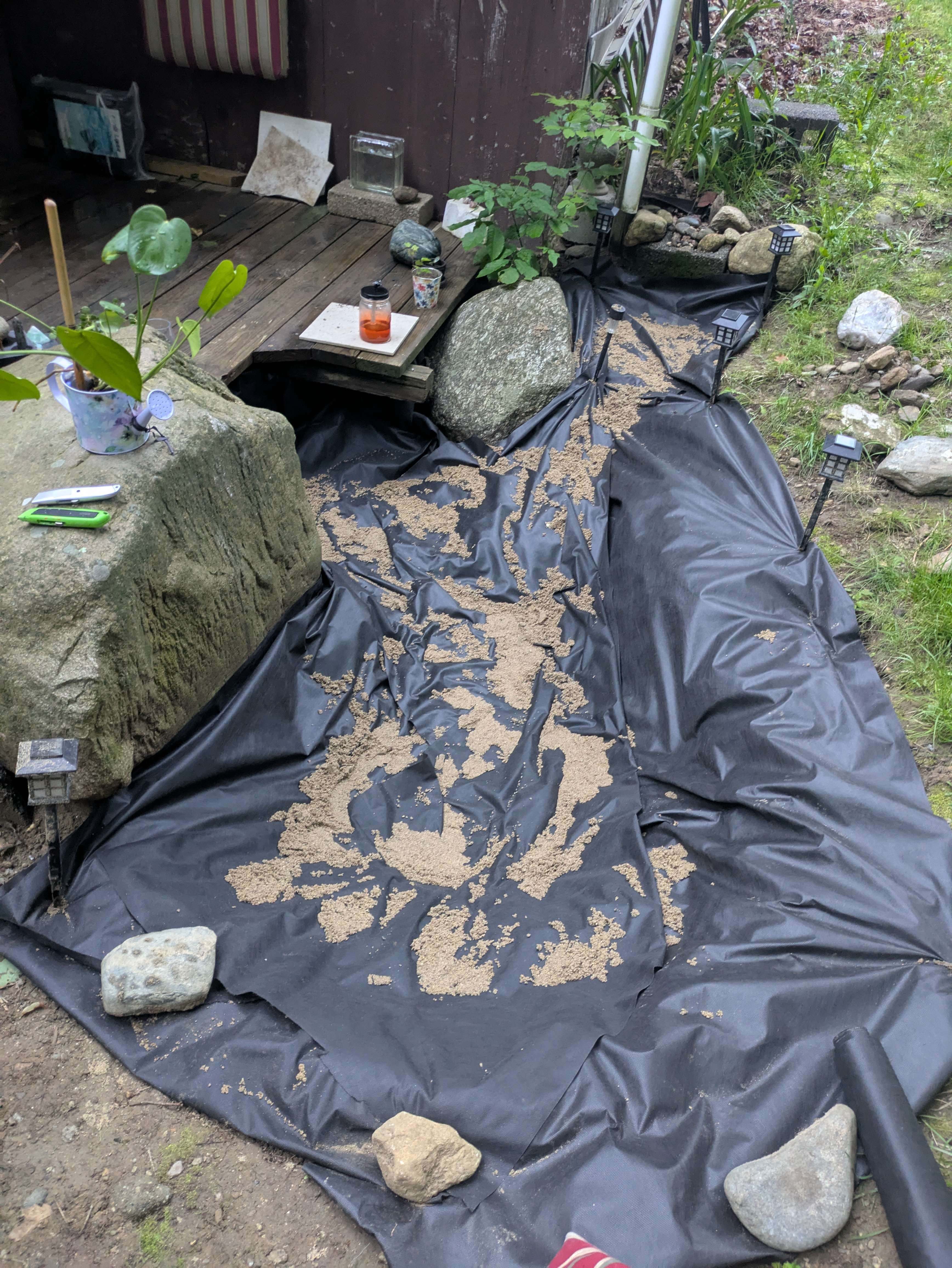 Pond liner being shaped around stones